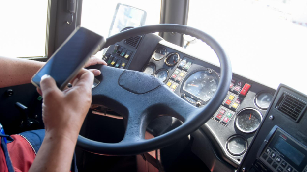 a person using a cell phone while operating a commercial vehicle