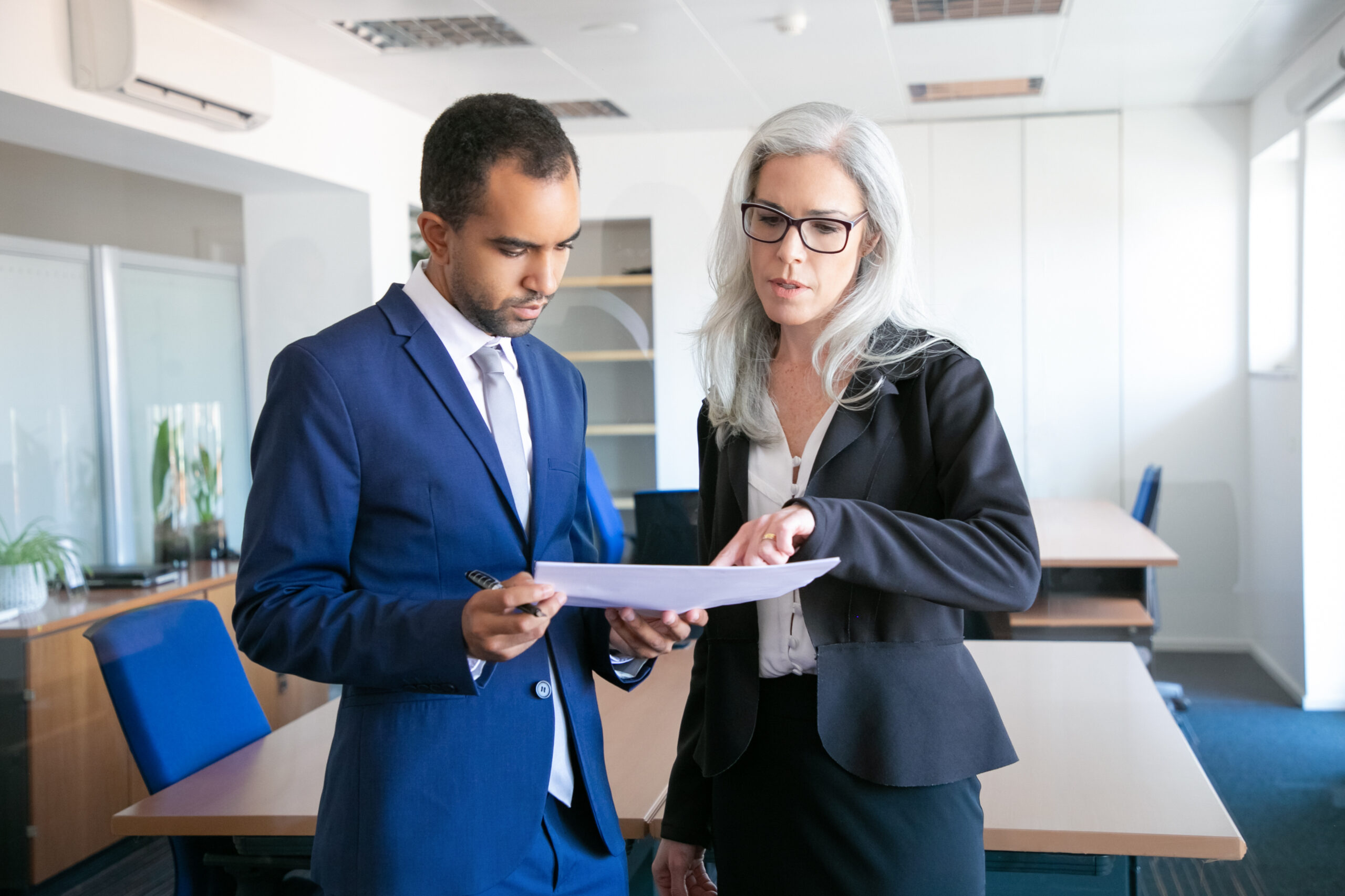 Two business professionals reviewing a document together in an office