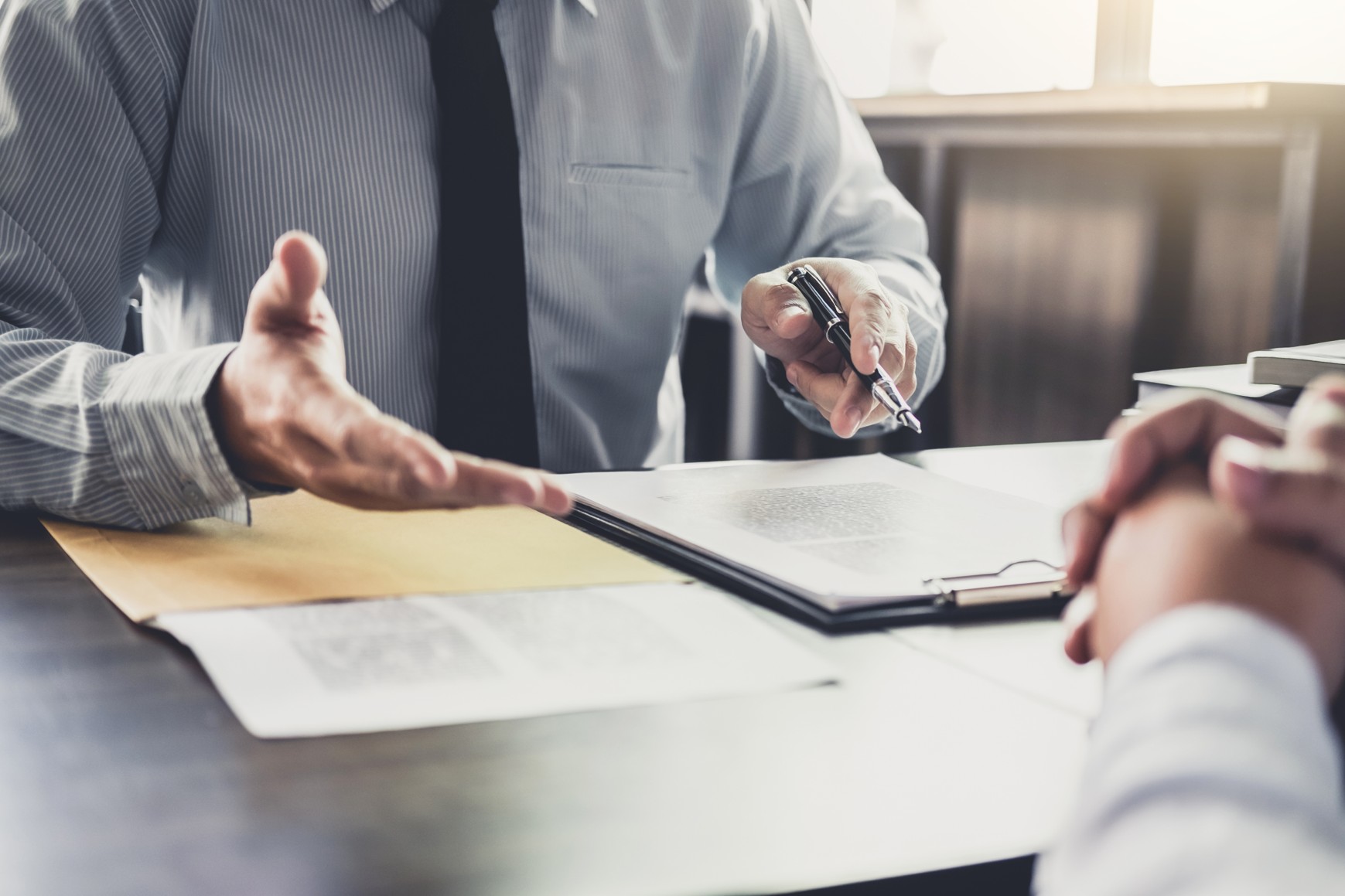 Buffalo brain injury lawyer discussing a client's TBI claim across a desk with case documents